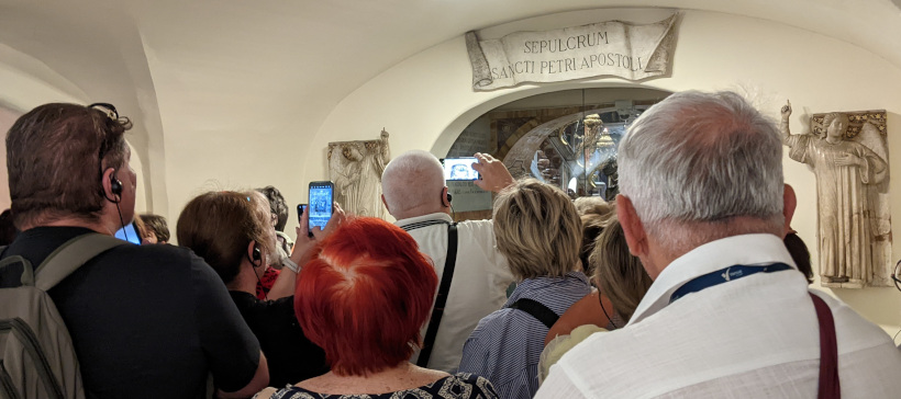 A whole bunch of people all trying to take a picture of St. Peter's Tomb at the same time.